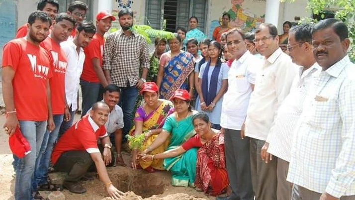 Volunteers planting trees in a park as part of a Go Green initiative.